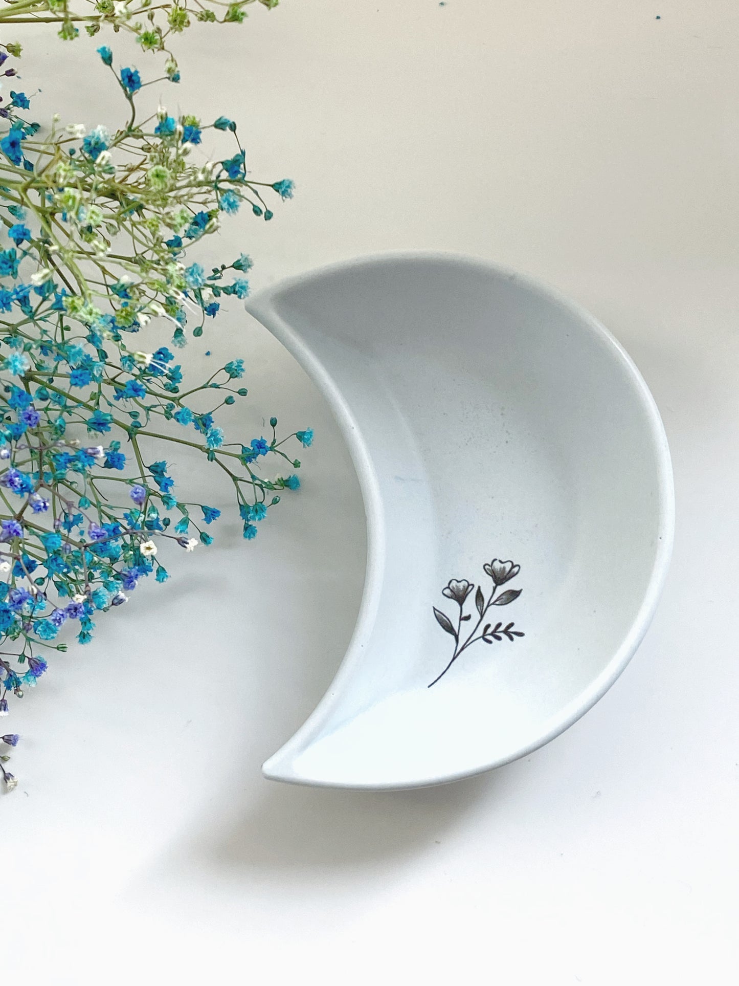 Lys blå måneskål med blomst