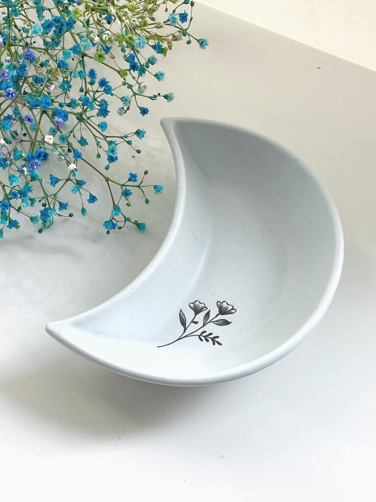 Lys blå måneskål med blomst