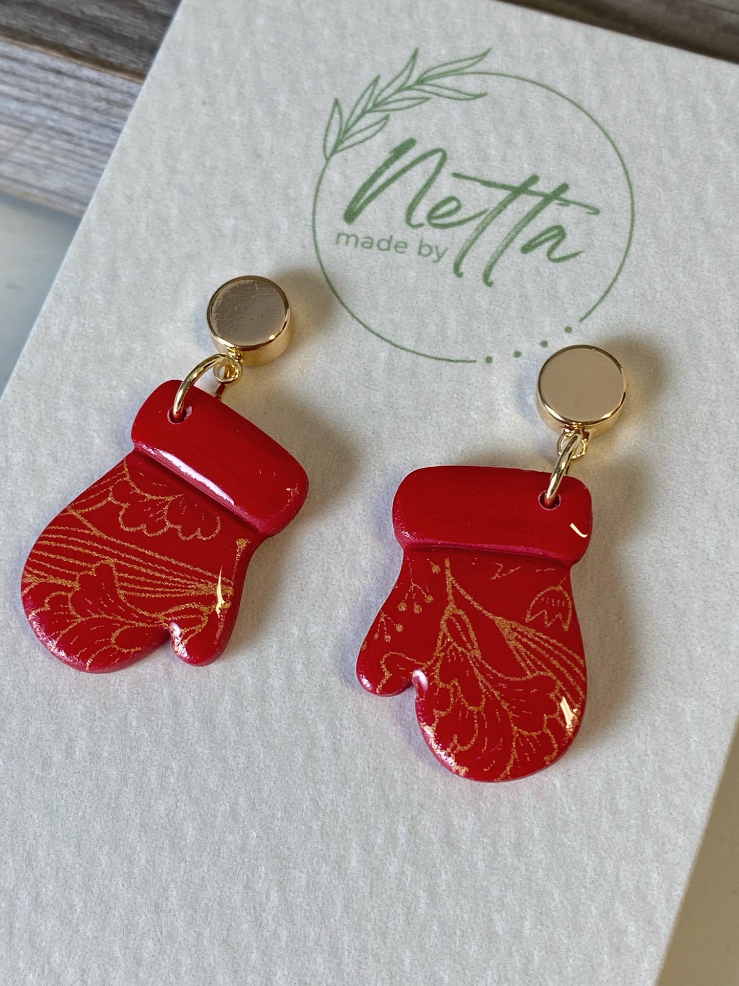 Røde votter med gullmønster